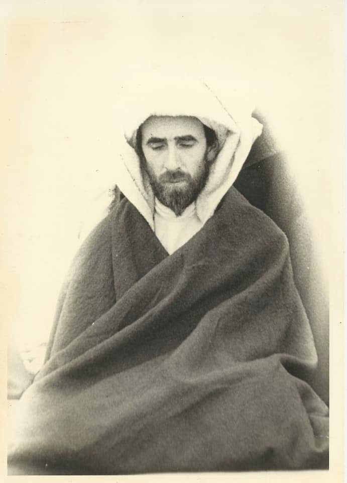 Shaykh Dr. Abdalqadir as-Sufi in a dark suit and ornate kufi cap during his international da’wa years